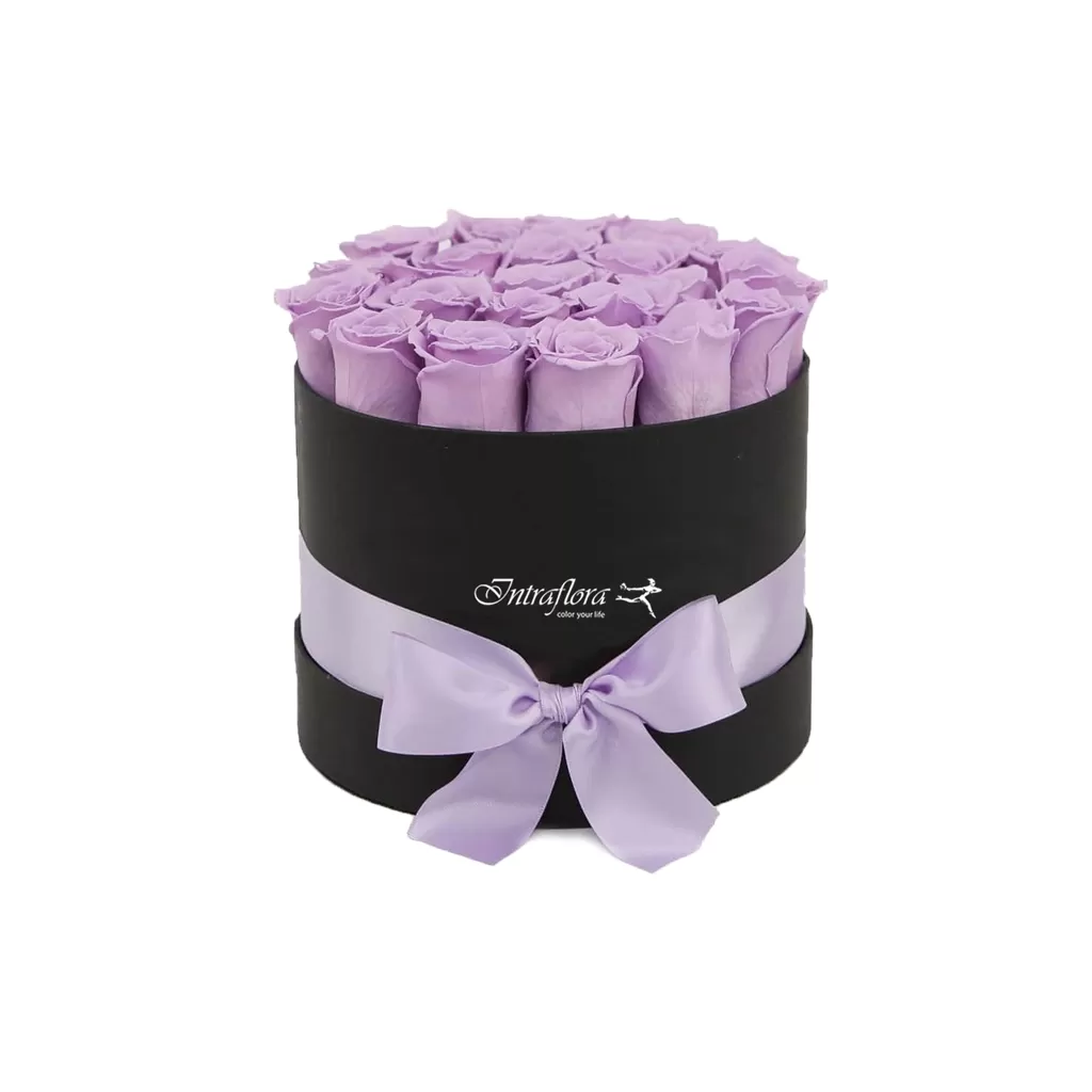 A black, cylindrical box filled with light purple roses, wrapped with a light purple ribbon and bow, against a white background. The box also features the "Intraflora" logo.