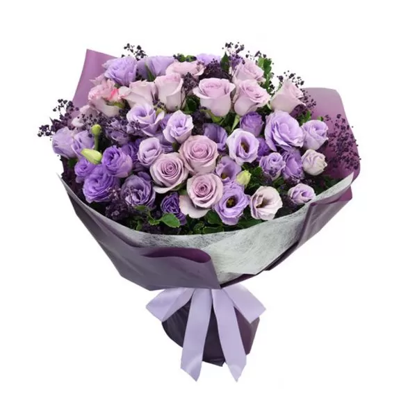 A close-up shot of a bouquet featuring purple roses and lisianthus flowers, with small dark purple accents, wrapped in dark purple paper and tied with a light purple ribbon.